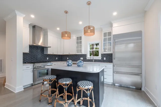 a kitchen with a refrigerator a sink and chairs