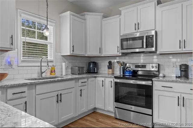 a kitchen with granite countertop white cabinets and white appliances