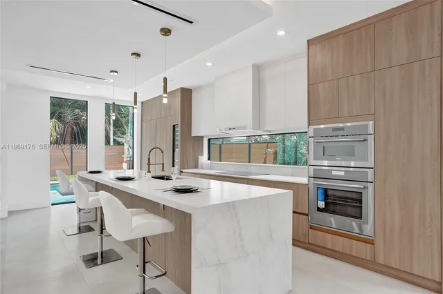 a large room with a lot of white furniture a window and a fireplace