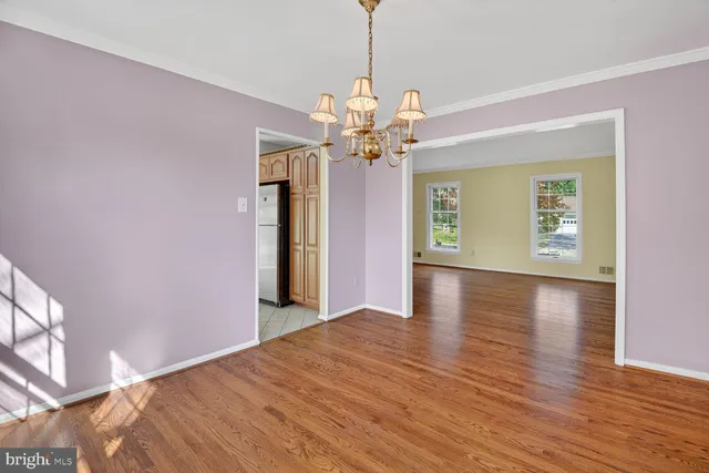 a view of a livingroom with wooden floor and a ceiling fan