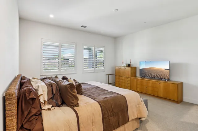 a view of a backyard with lawn chairs under an umbrella