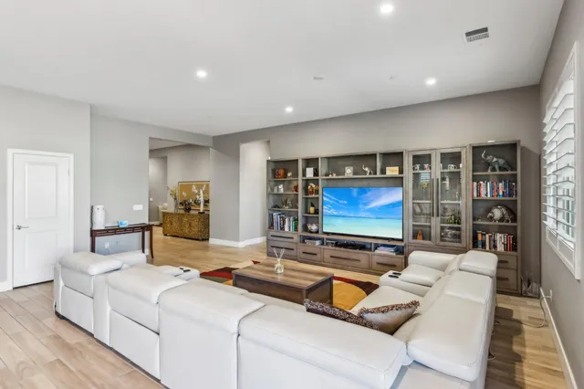 a view of a dining room and livingroom with furniture wooden floor a chandelier