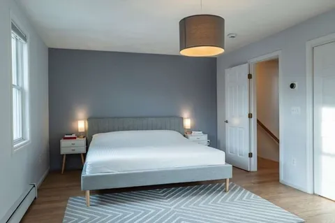 a hallway with a chair and potted plant next to a window