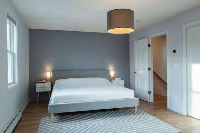 a hallway with a chair and potted plant next to a window