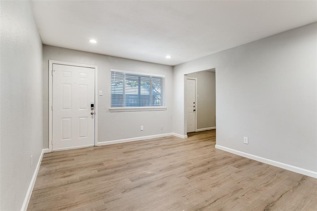 4618 Reiger Avenue, Unit 211 Dallas, TX 75246 - Photo 11 of 19 a view of an empty room with wooden floor and a window