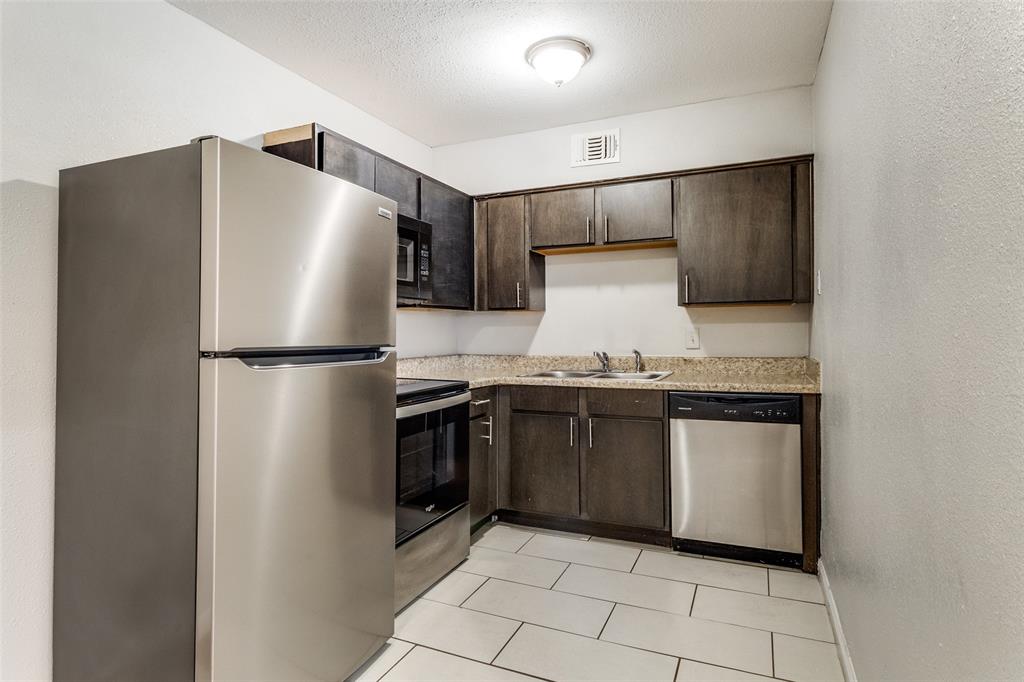 4618 Reiger Avenue, Unit 211 Dallas, TX 75246 - Photo 13 of 19 a kitchen with granite countertop a refrigerator and a sink
