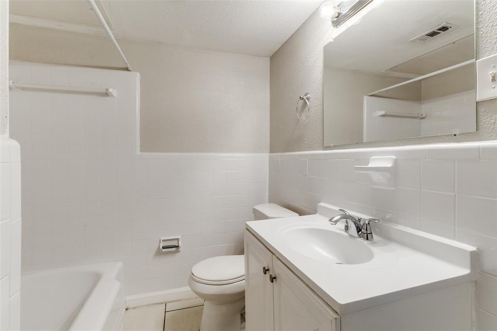 4618 Reiger Avenue, Unit 211 Dallas, TX 75246 - Photo 18 of 19 a bathroom with a sink toilet and mirror