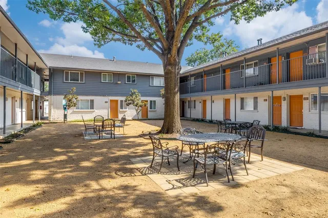 a view of a patio with a table and chairs and wooden fence