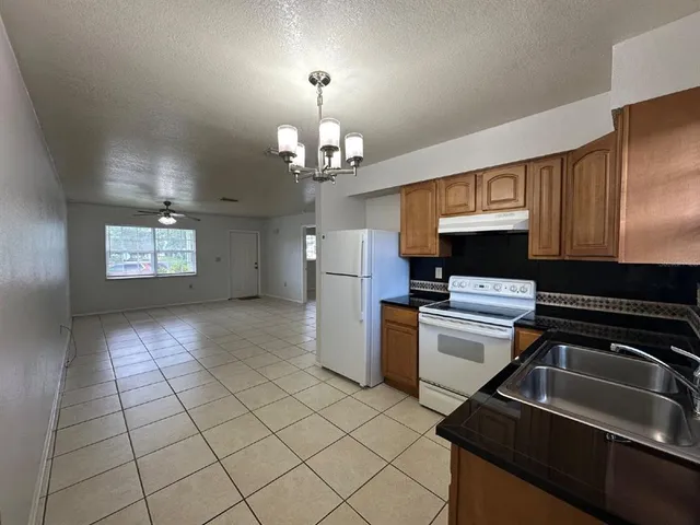 a kitchen that has a sink stainless steel appliances and cabinets