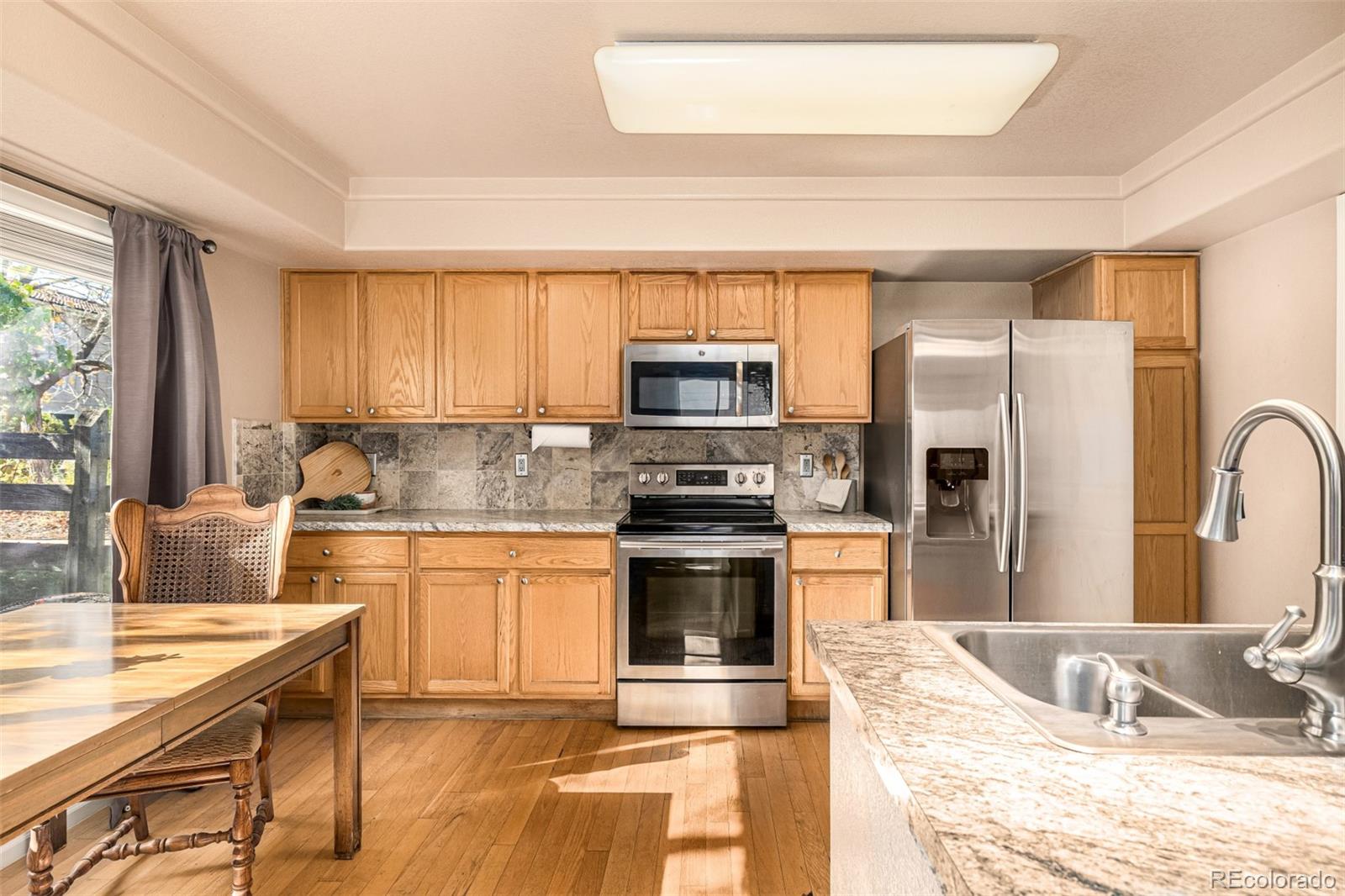 21300 East 42nd Avenue Denver, CO 80249 - Photo 17 of 48 a kitchen with stainless steel appliances granite countertop a stove refrigerator sink and microwave