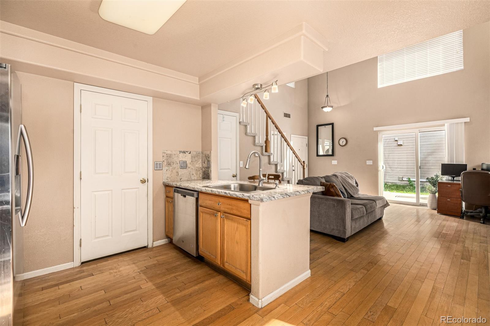 21300 East 42nd Avenue Denver, CO 80249 - Photo 19 of 48 a living room with stainless steel appliances granite countertop furniture a refrigerator a sink and wooden floor