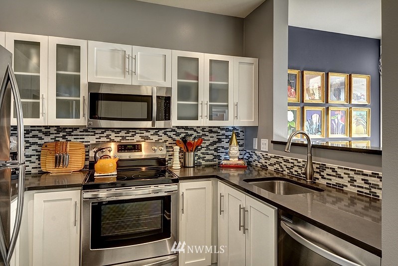 2415 2nd Avenue, Unit 547 Seattle, WA 98121 - Photo 7 of 20 a kitchen with stainless steel appliances a stove sink and microwave