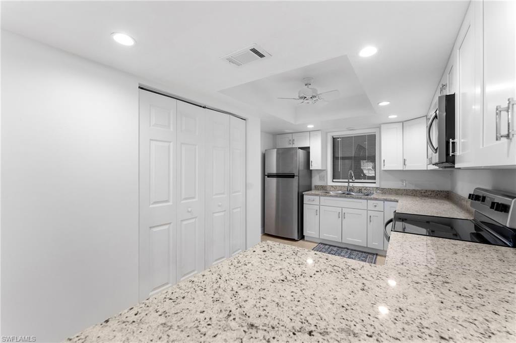 14053 Northumberland Drive Southwest, Unit 105 Fort Myers, FL 33908 - Photo 11 of 38 a kitchen with refrigerator cabinets and a stove