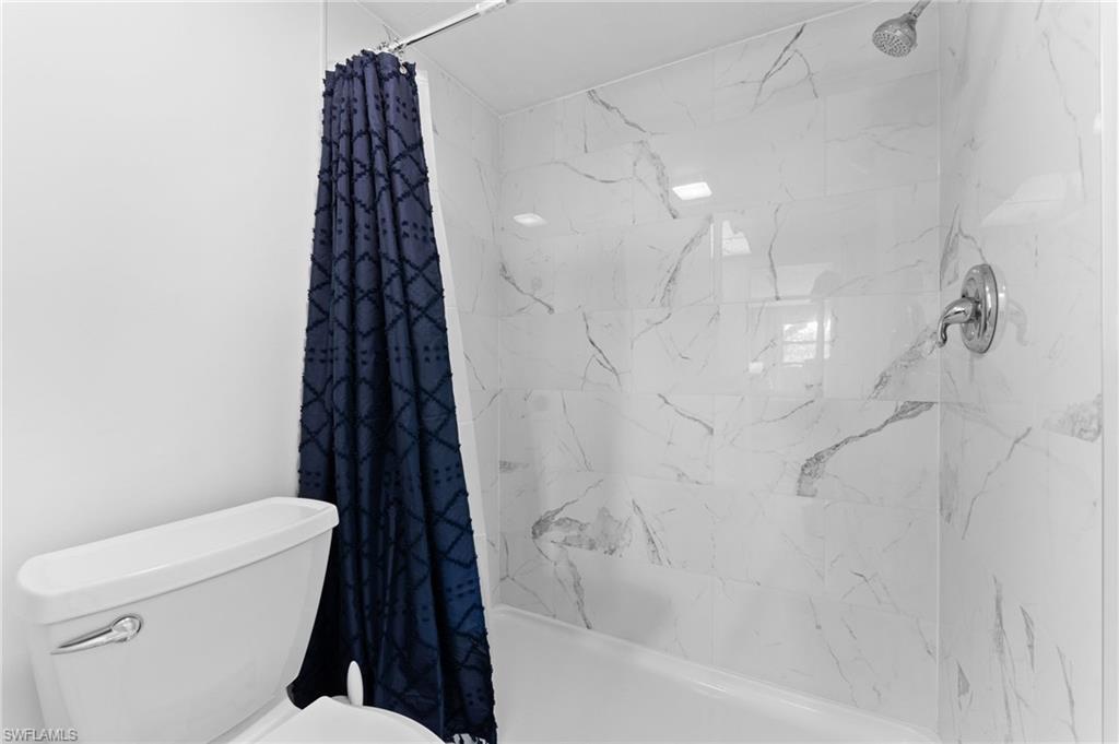14053 Northumberland Drive Southwest, Unit 105 Fort Myers, FL 33908 - Photo 19 of 38 a bathroom with a toilet and a bathtub