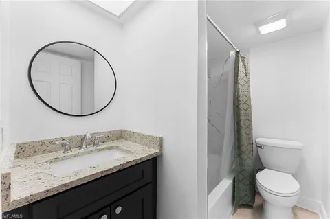 a white toilet sitting next to a shower