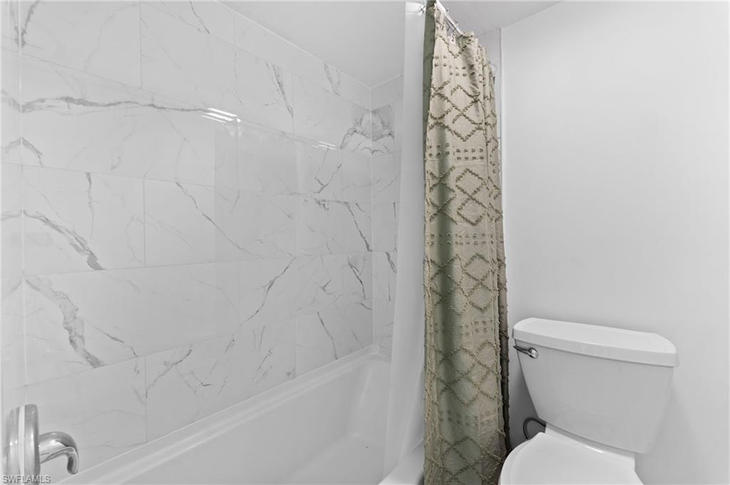 14053 Northumberland Drive Southwest, Unit 105 Fort Myers, FL 33908 - Photo 24 of 38 a white toilet sitting next to a shower