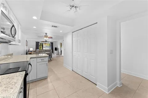 a large white kitchen with a sink and dishwasher a stove top oven with wooden floor