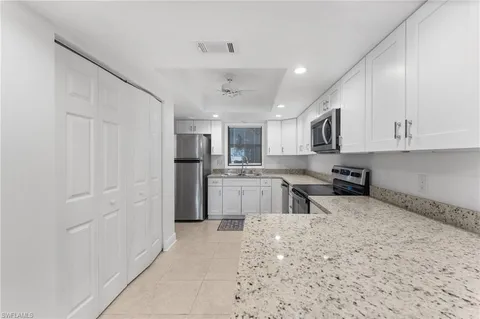 a kitchen with stainless steel appliances granite countertop a refrigerator sink and cabinets