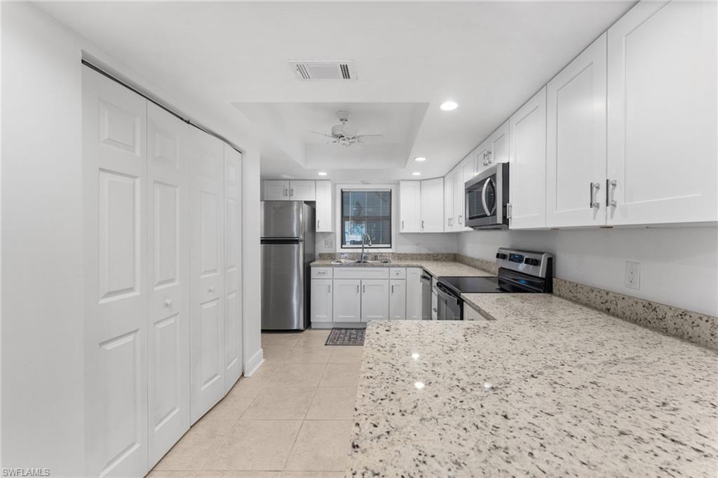 14053 Northumberland Drive Southwest, Unit 105 Fort Myers, FL 33908 - Photo 9 of 38 a kitchen with stainless steel appliances granite countertop a refrigerator sink and cabinets