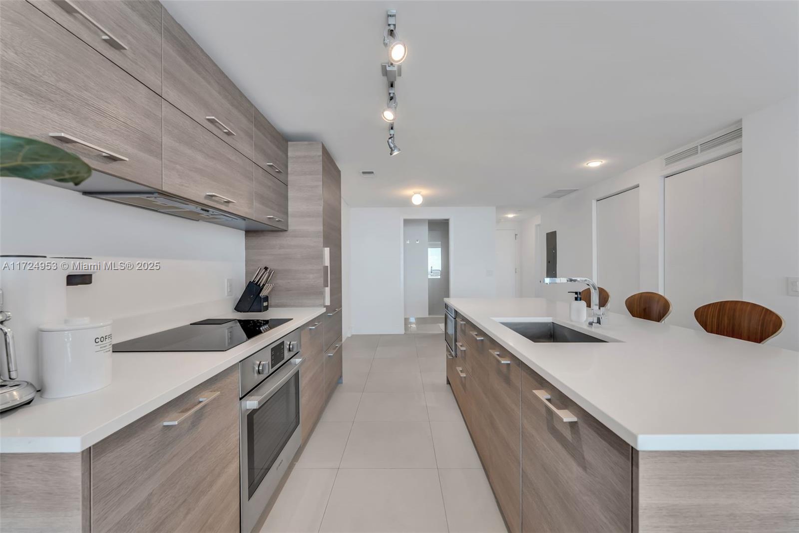 650 Northeast 32nd Street, Unit 2703 Miami, FL 33137 - Photo 14 of 48 a kitchen with a sink a stove and cabinets