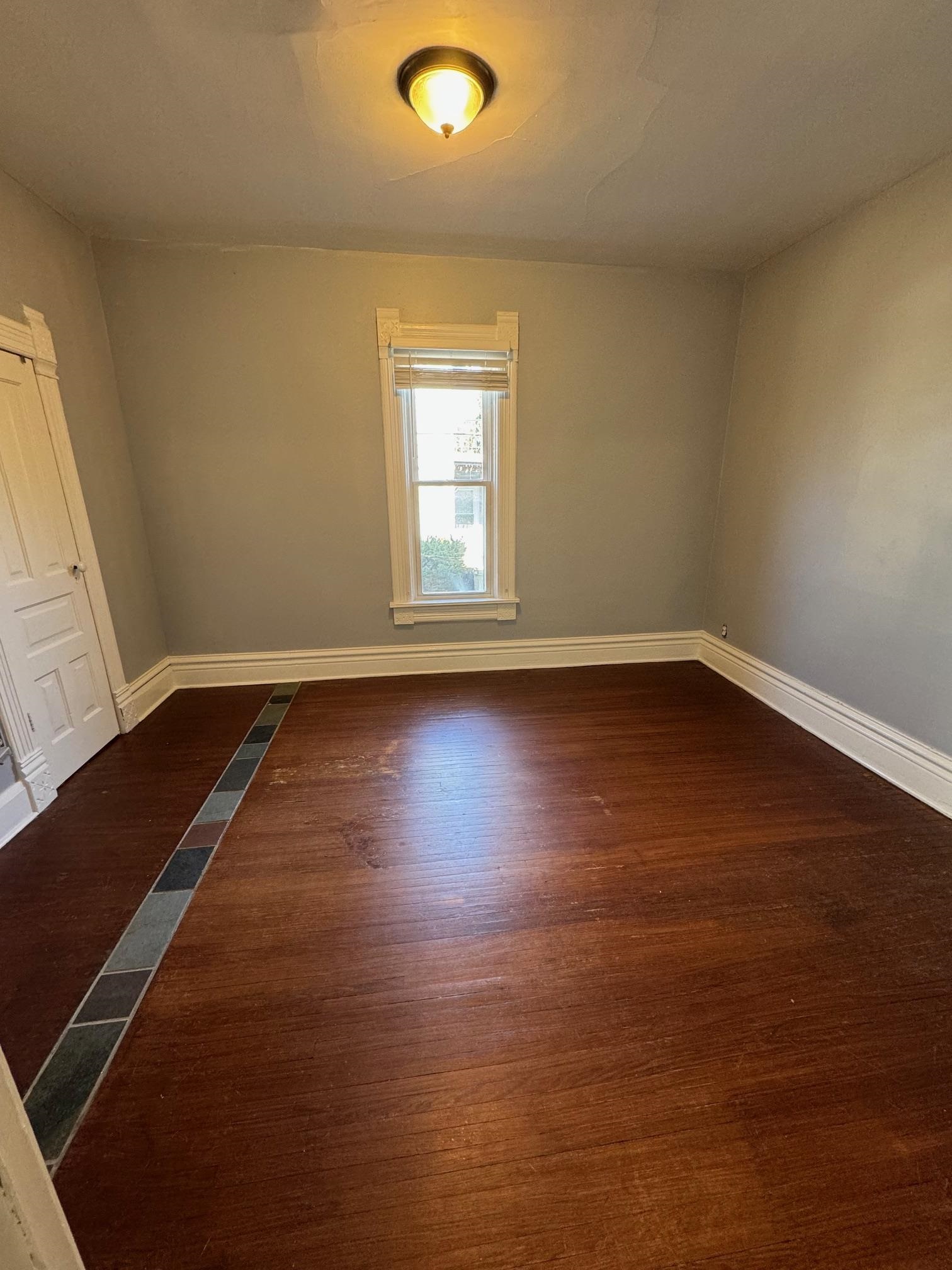 124 South Prospect Street Rockford, IL 61104 - Photo 7 of 13 an empty room with wooden floor and windows