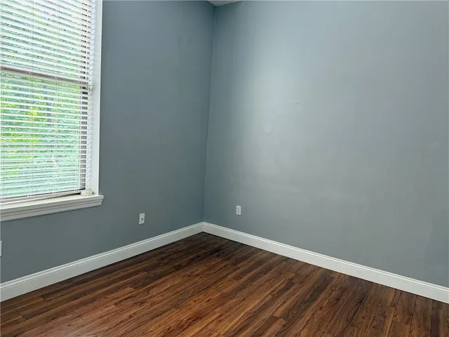 a view of a room with wooden floor and a window