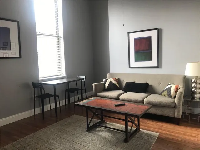a living room with furniture a lamp on table and a window