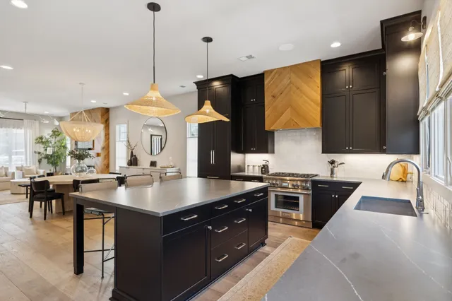 a kitchen with stainless steel appliances granite countertop a stove a kitchen island a sink a refrigerator and a stove