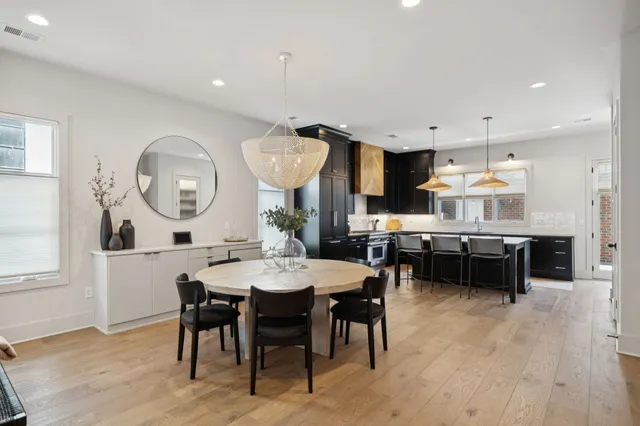 a dining area with a table chairs and a kitchen view
