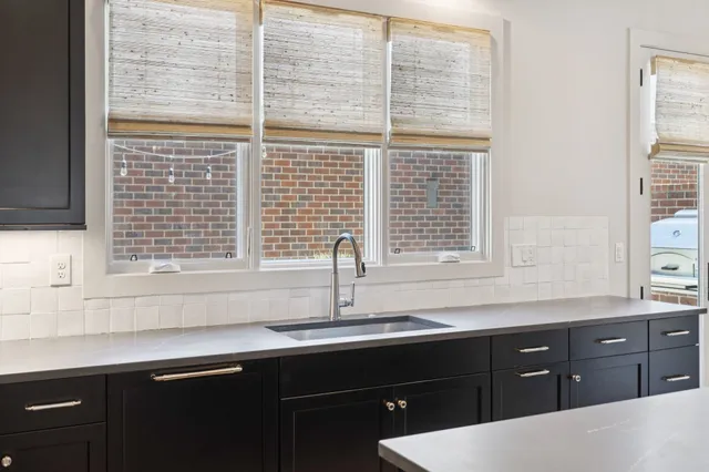 a sink with a window and cabinets
