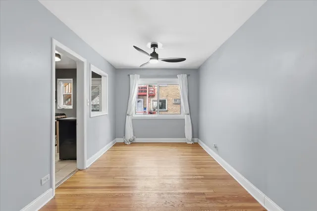 an empty room with windows and a ceiling fan