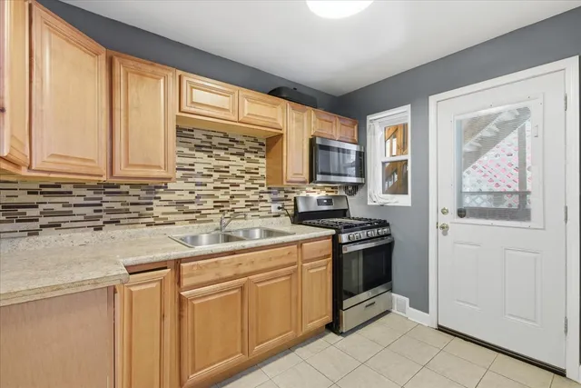 a kitchen with stainless steel appliances granite countertop a stove a sink and white cabinets