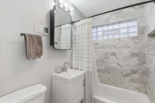 a bathroom with a sink and mirror with bathtub