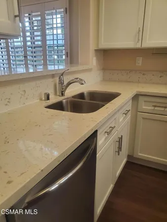 a view with granite countertop a sink and a stove