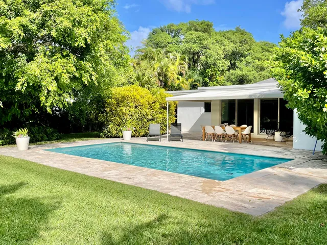 a view of a house with swimming pool and a yard