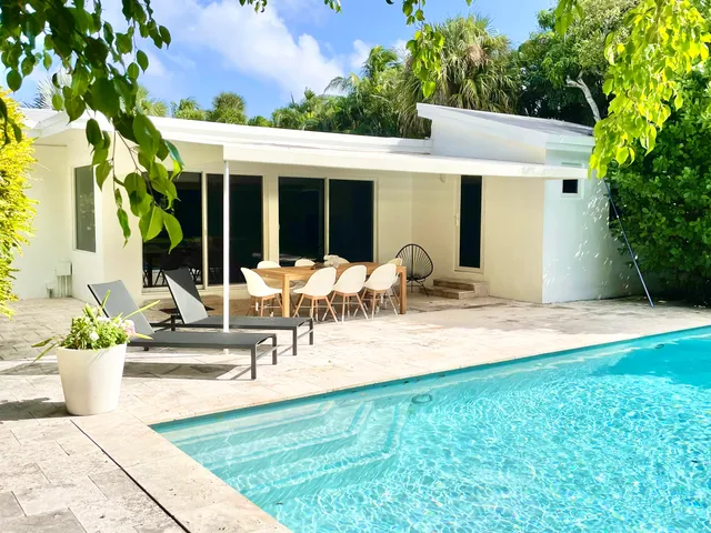 a view of a patio with table and chairs potted plants and large tree