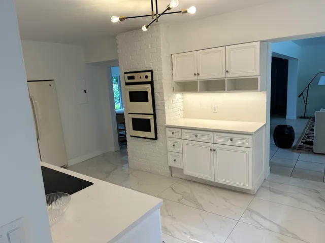 a kitchen with a refrigerator and white cabinets