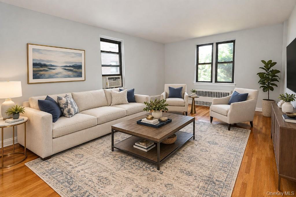 Photo visually staged Large Corner Living Room with Hardwood floors opens to the dining foyer and overlooking Tree Lined Garth Road.  The living room is 19'-10" x 12'-2".
