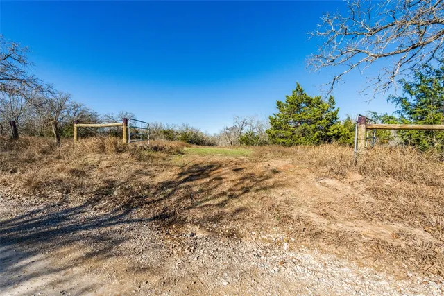 a view of a yard with wooden fence