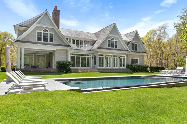 a front view of a house with swimming pool having outdoor seating