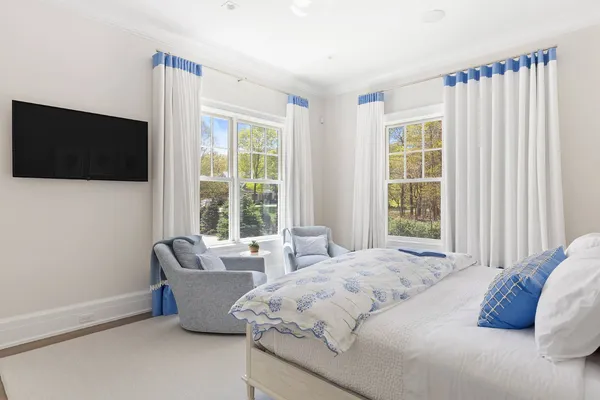 a bedroom with bed and a flat screen tv