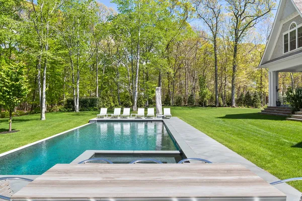 a view of backyard with swimming pool and green space