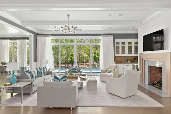 a living room with fireplace furniture and a large window