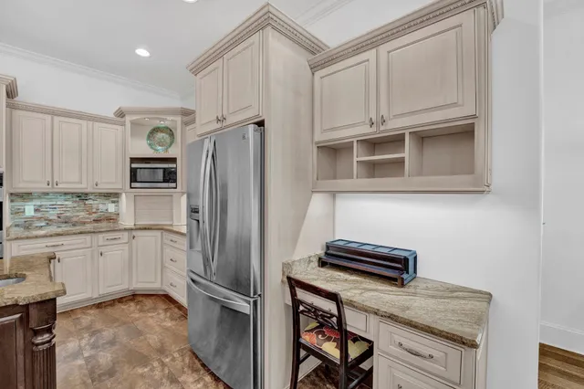 a kitchen with stainless steel appliances granite countertop a refrigerator and a stove top oven