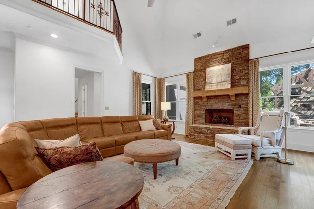 a living room with furniture a fireplace and a large window