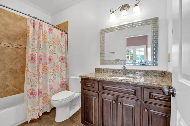 a bathroom with a granite countertop sink mirror vanity and toilet