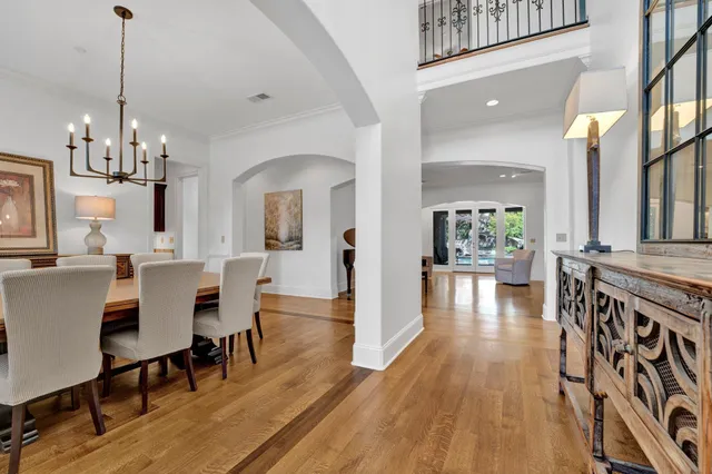 a view of a dining room and livingroom with furniture wooden floor a chandelier