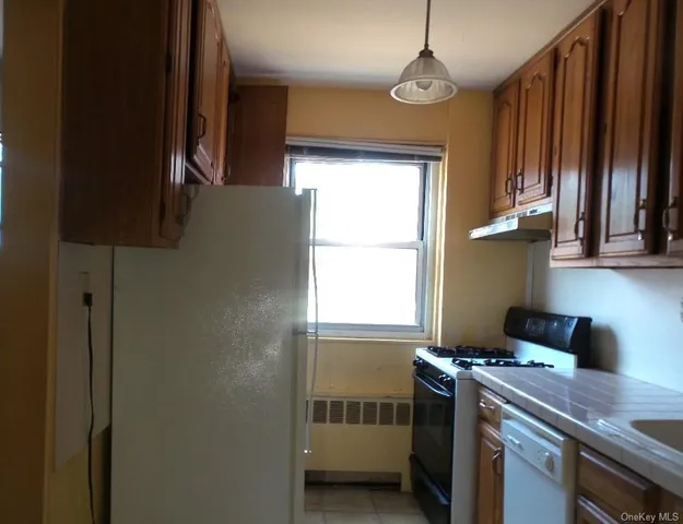 a kitchen that has a window wooden cabinets and a stove