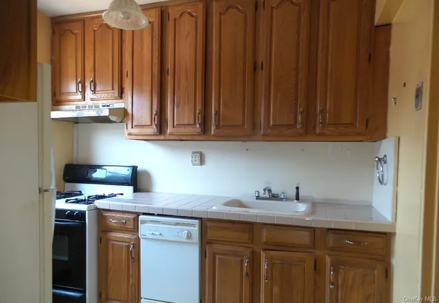 a kitchen with stainless steel appliances granite countertop a sink dishwasher and cabinets with wooden floor