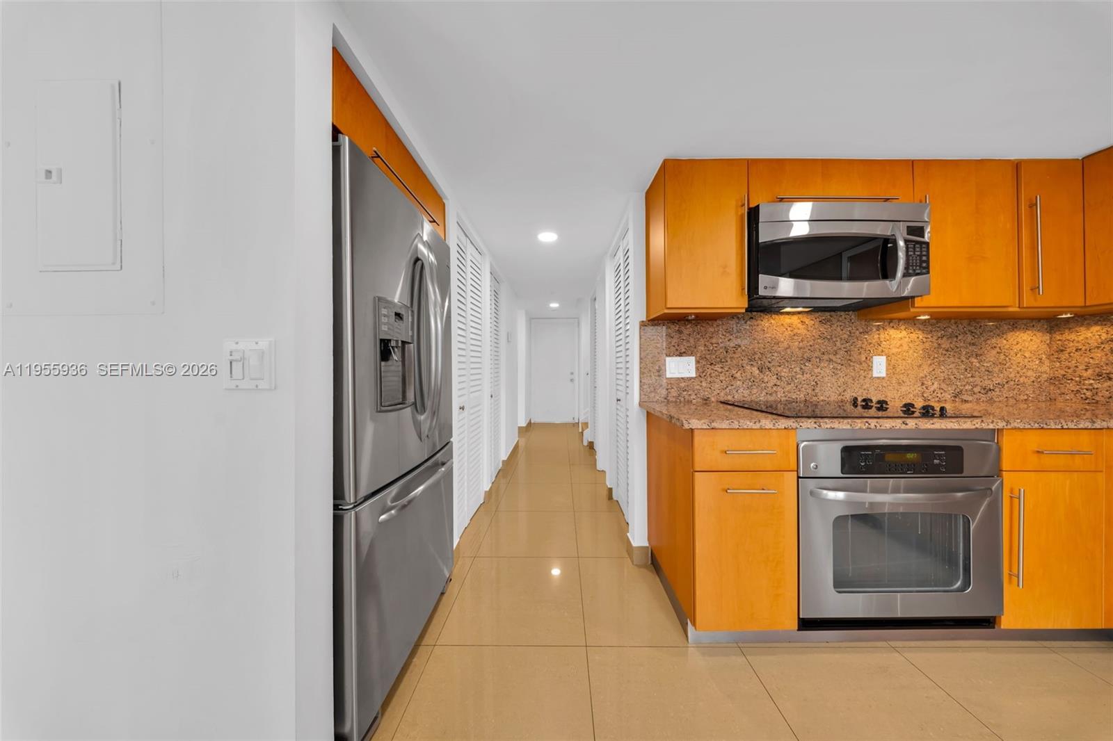 6960 Southwest 54th Street Miami, FL 33155 - Photo 23 of 55 a kitchen with stainless steel appliances granite countertop a stove a microwave and a refrigerator